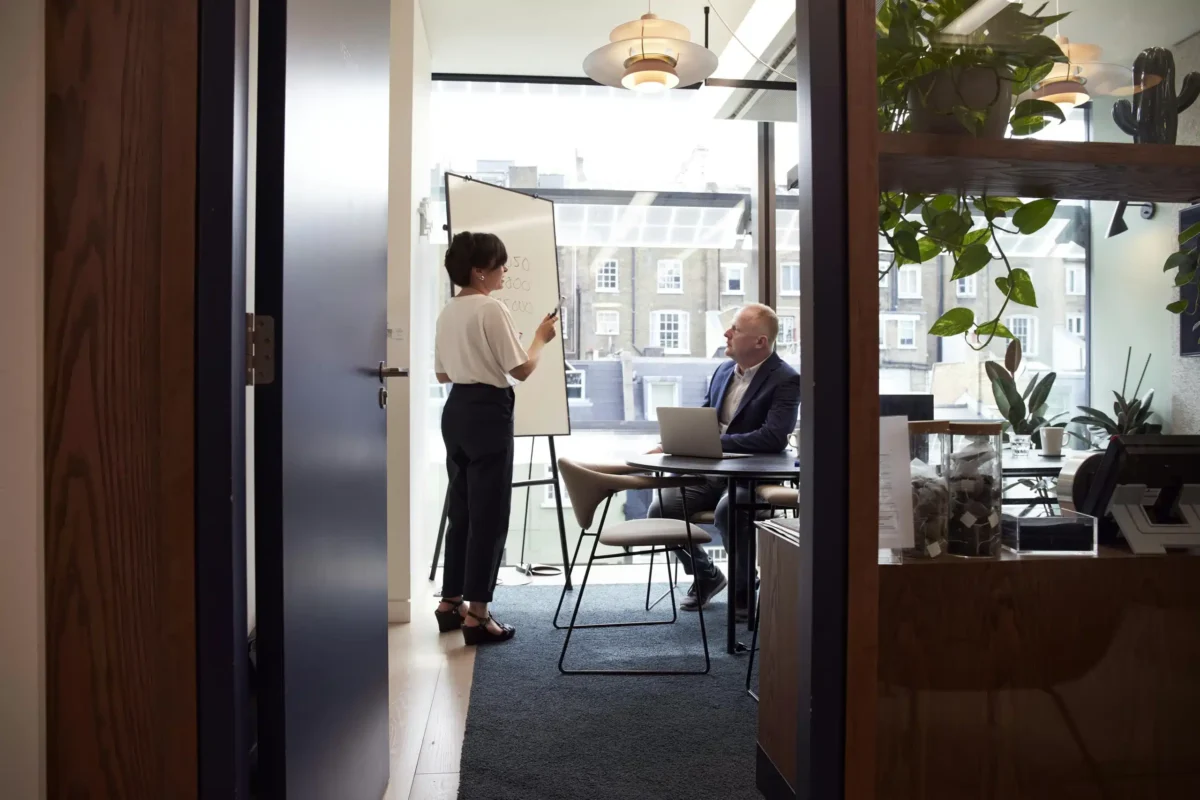 Femme présentant une idée à un homme dans un bureau.