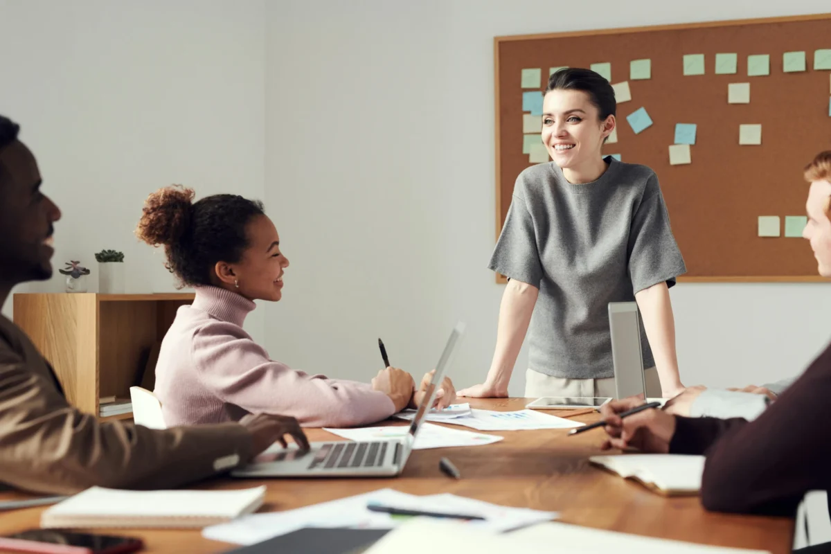 A woman leads a brainstorming meeting for multiple colleagues.