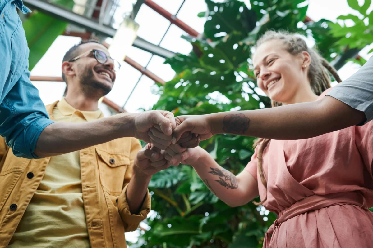 Group of four people fist bumping.