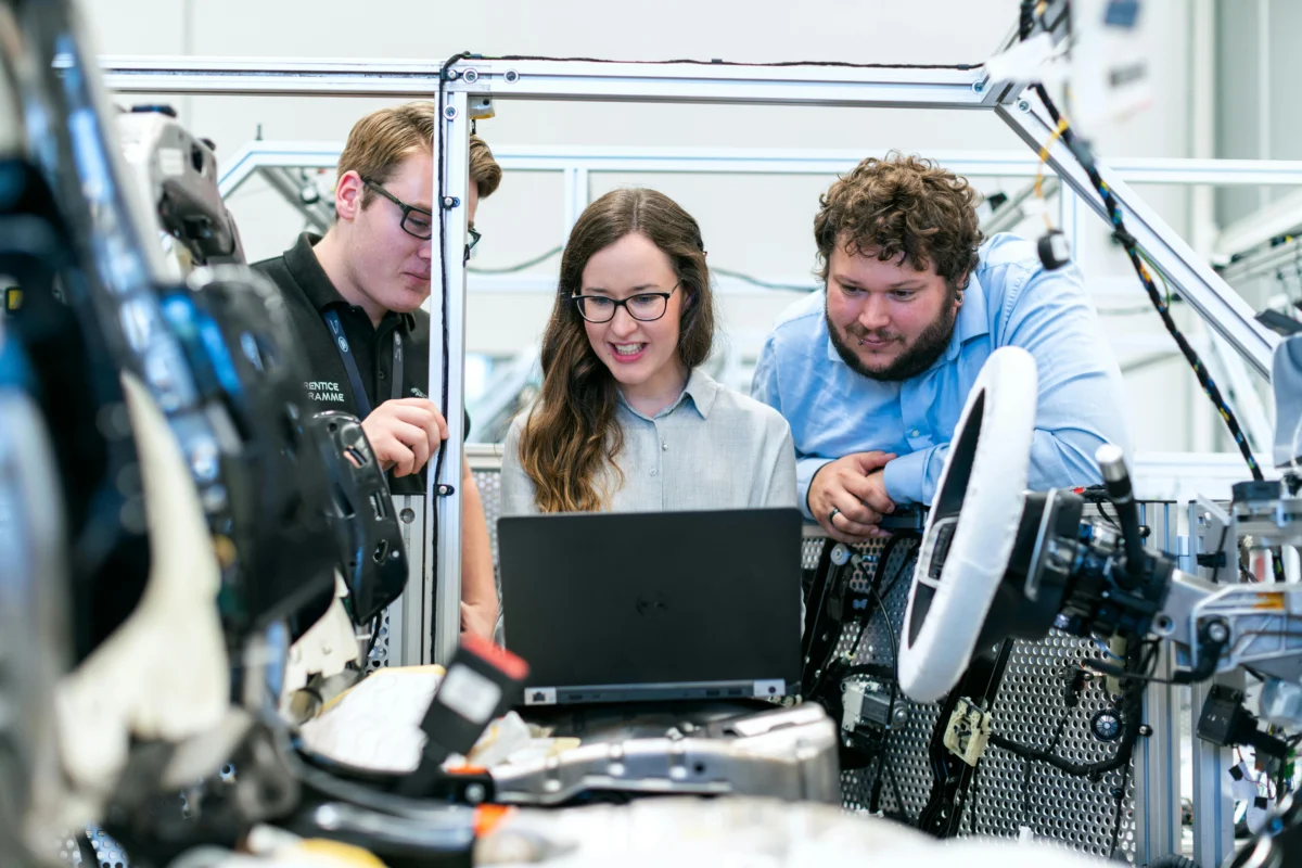 A team of three engineers in a workshop.