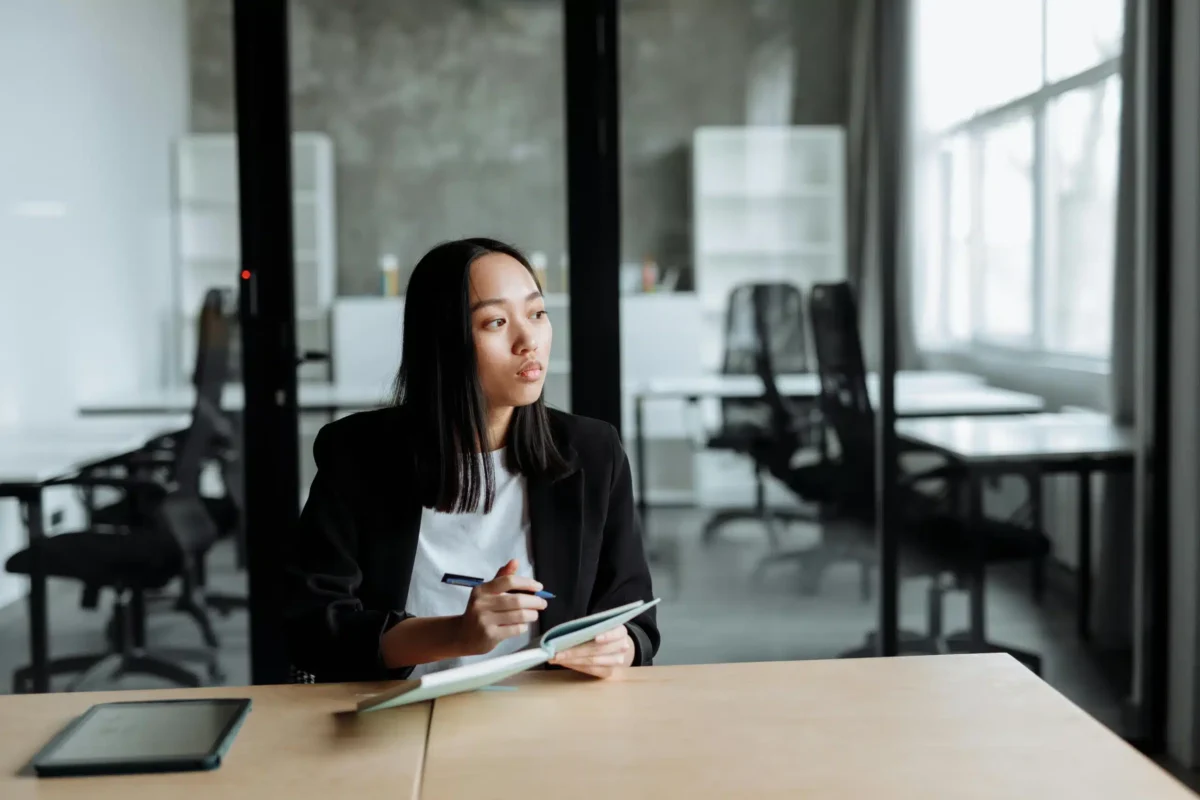 Woman in an office taking notes in her notebook.