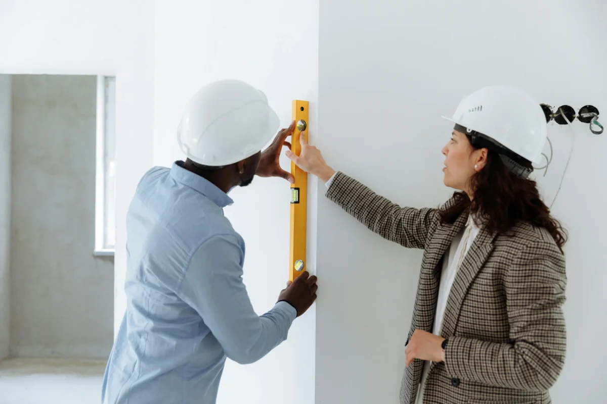 Un homme et une femme prenant des mesures dans une construction neuve.