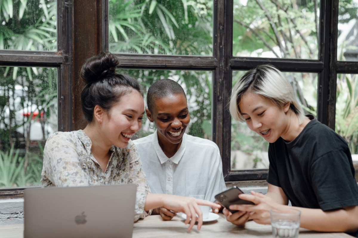 Three women working together in a meeting room.