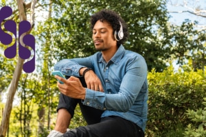 Man relaxing outside and listening to music with headphones.
