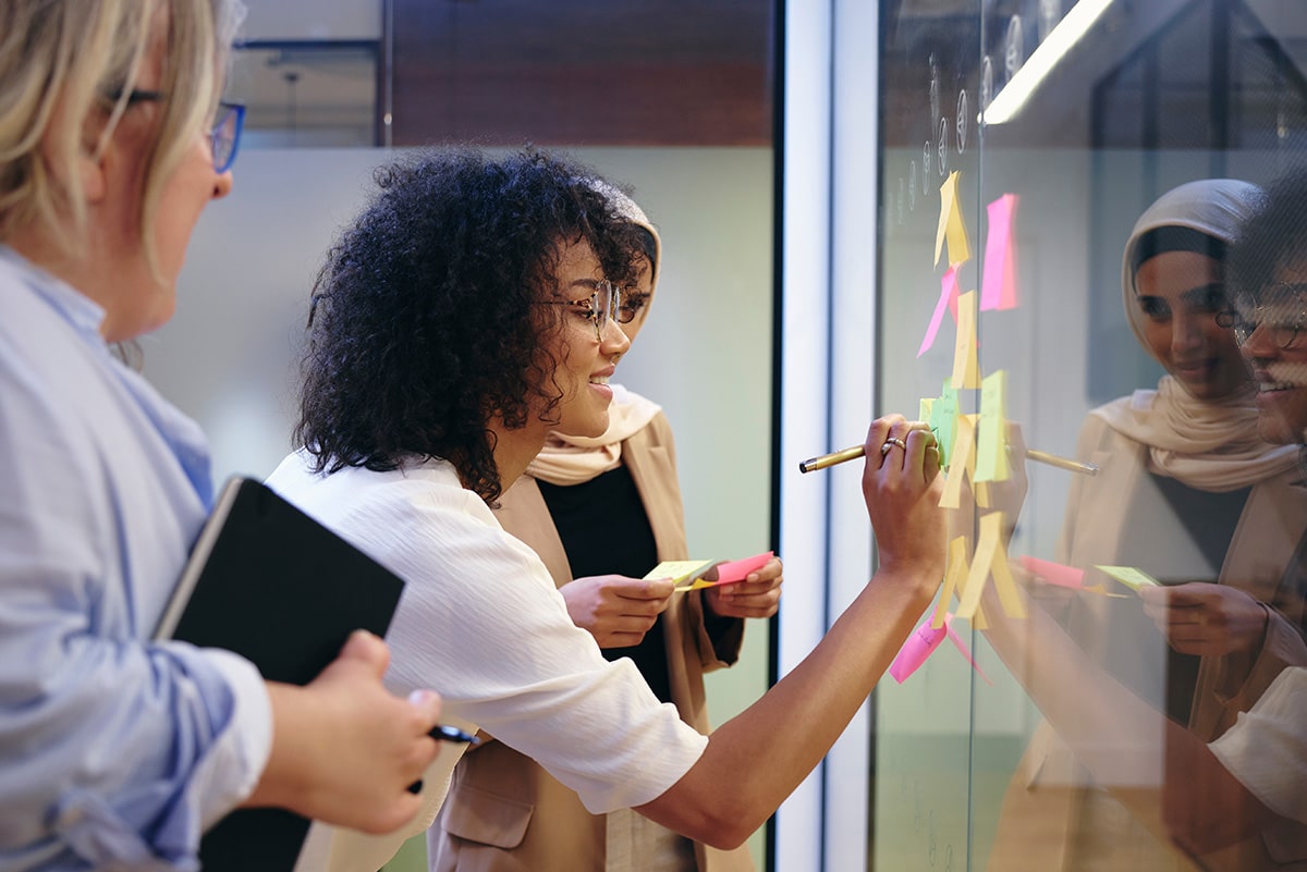 A group of employees writing on sticky notes during an employee development session.