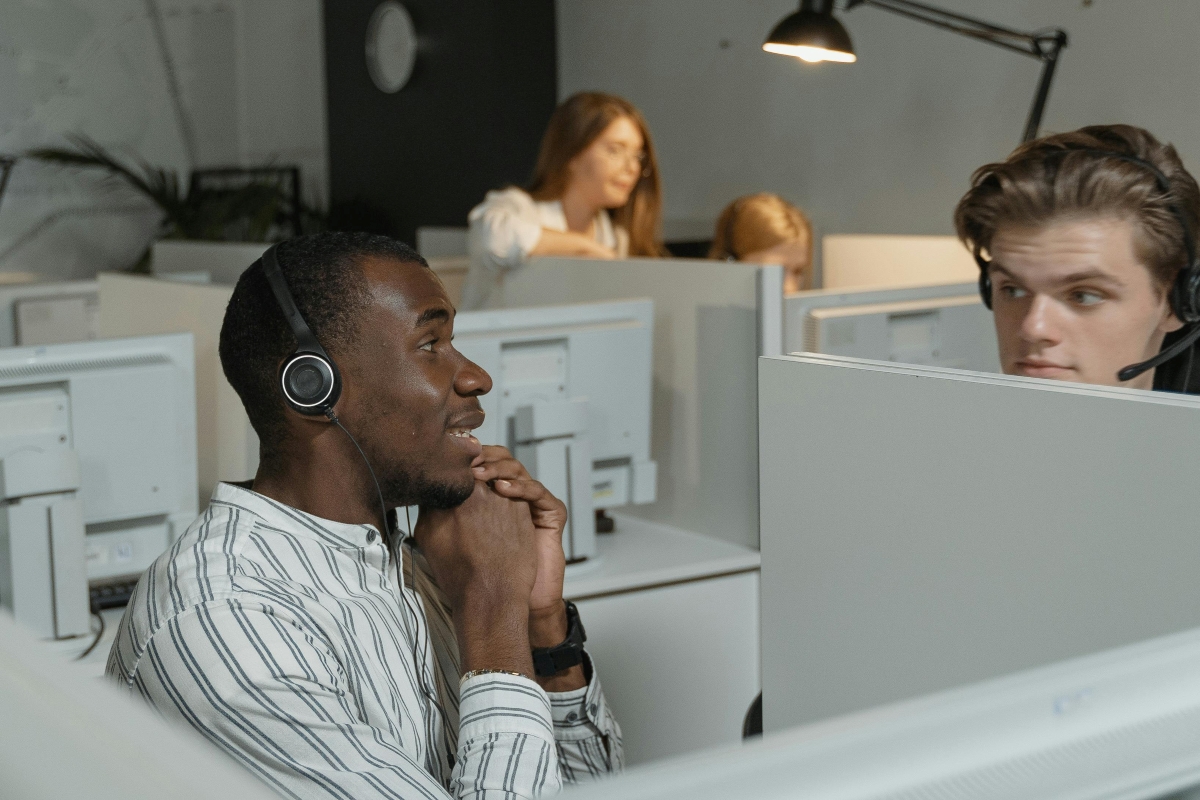 Two customer service representatives talking to each other from their cubicles.